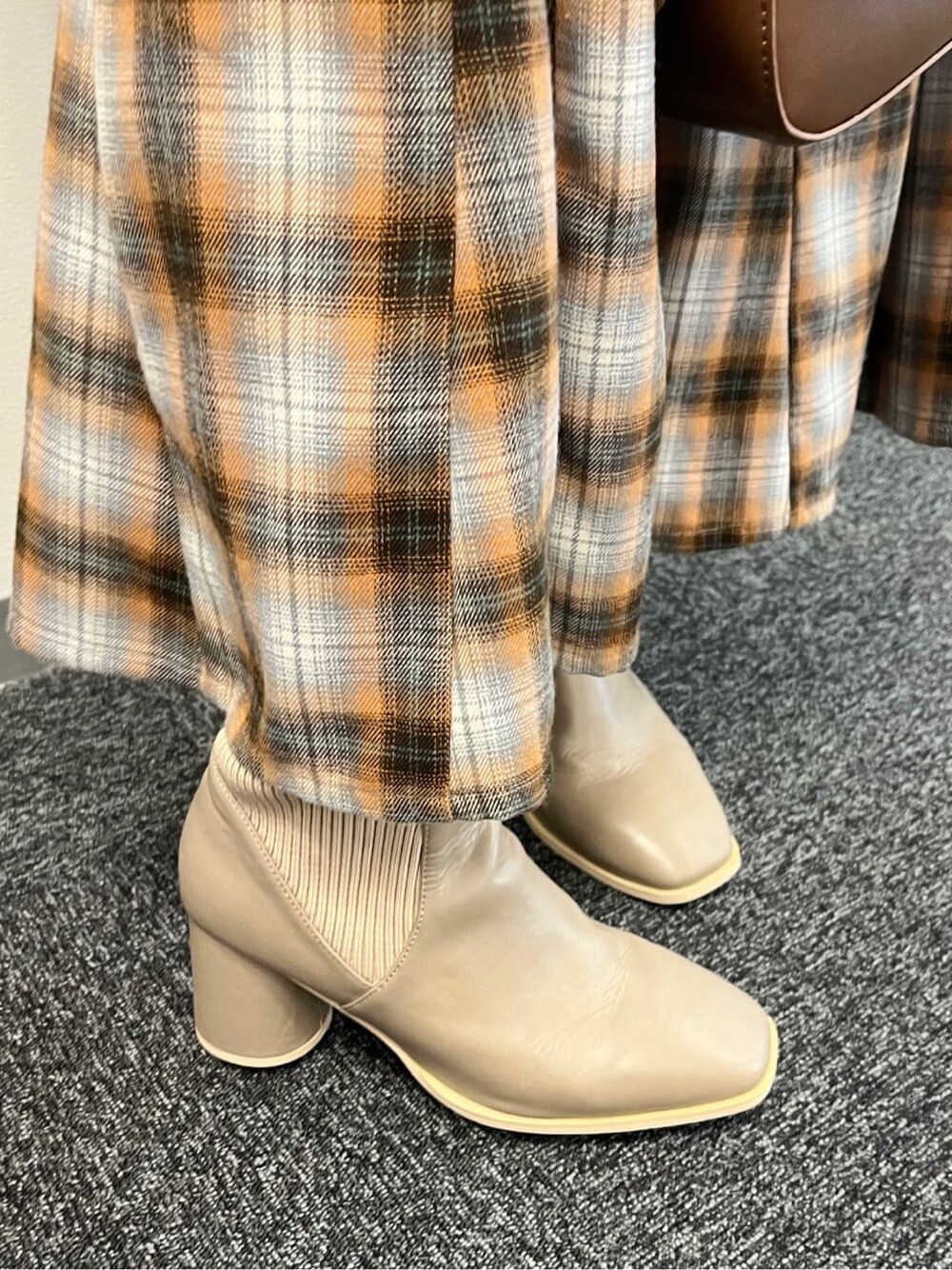 オレンジ系のワンピース、ベージュ系のブーツを着用したレディースの夏コーディネートの10枚目の写真