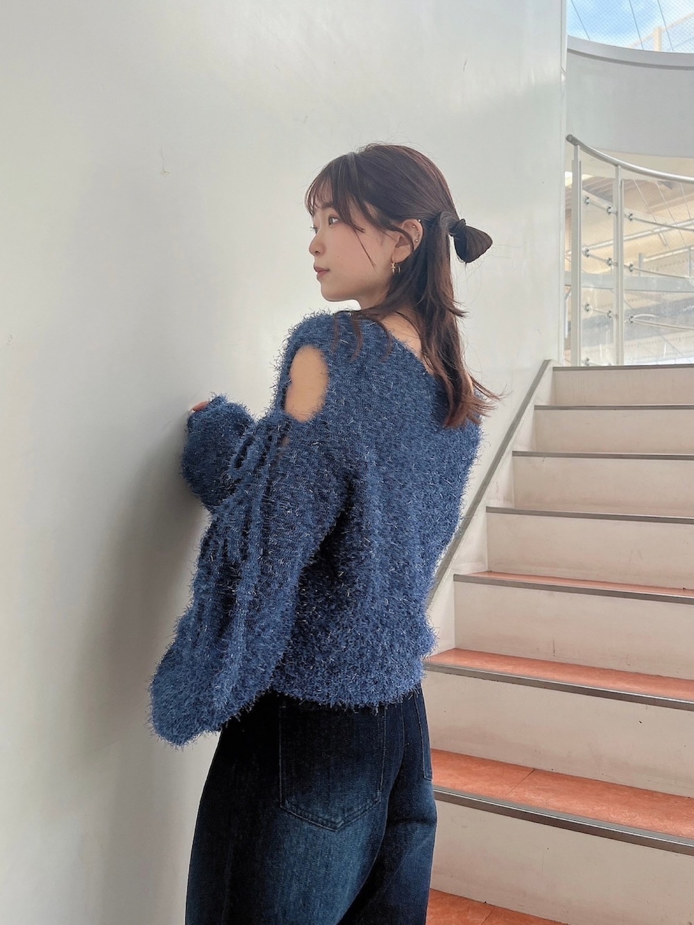 ブルー系のニット/セーター、ブルー系のデニムパンツ、ホワイト系のサンダルを着用したレディースの夏コーディネートの7枚目の写真