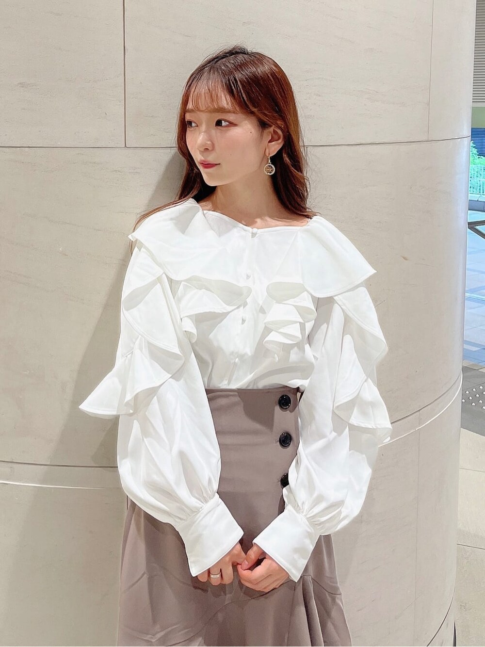 ベージュ系のブーツ、ベージュ系のスカート、ホワイト系のシャツ/ブラウスを着用したレディースの秋コーディネートの8枚目の写真