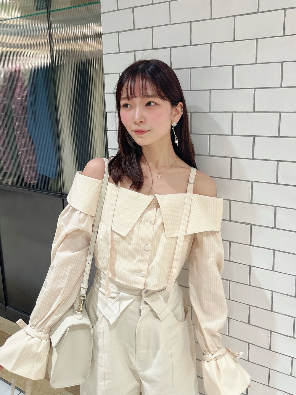 イエロー系のシャツ/ブラウス、ホワイト系のデニムパンツを着用したレディースの春コーディネートの5枚目の写真