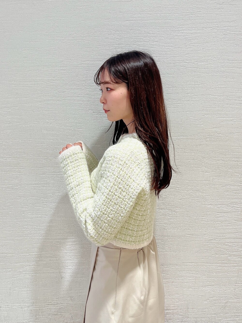 グリーン系のノーカラージャケット、ホワイト系のブーツ、ホワイト系のスカートを着用したレディースの冬コーディネートの7枚目の写真