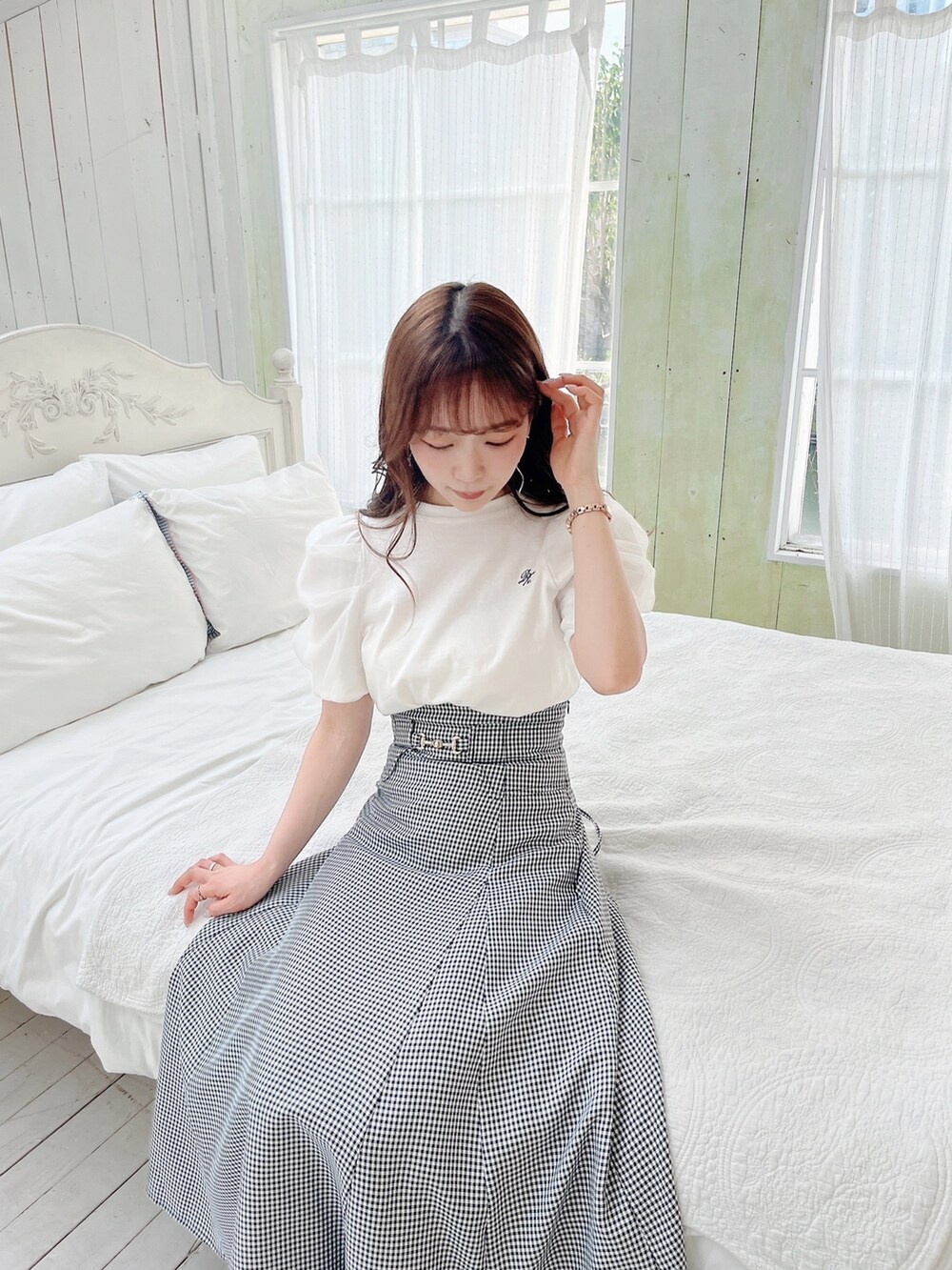 ホワイト系のTシャツ/カットソー、ブラック系のスカート、ブラック系のパンプスを着用したレディースの春コーディネートの4枚目の写真