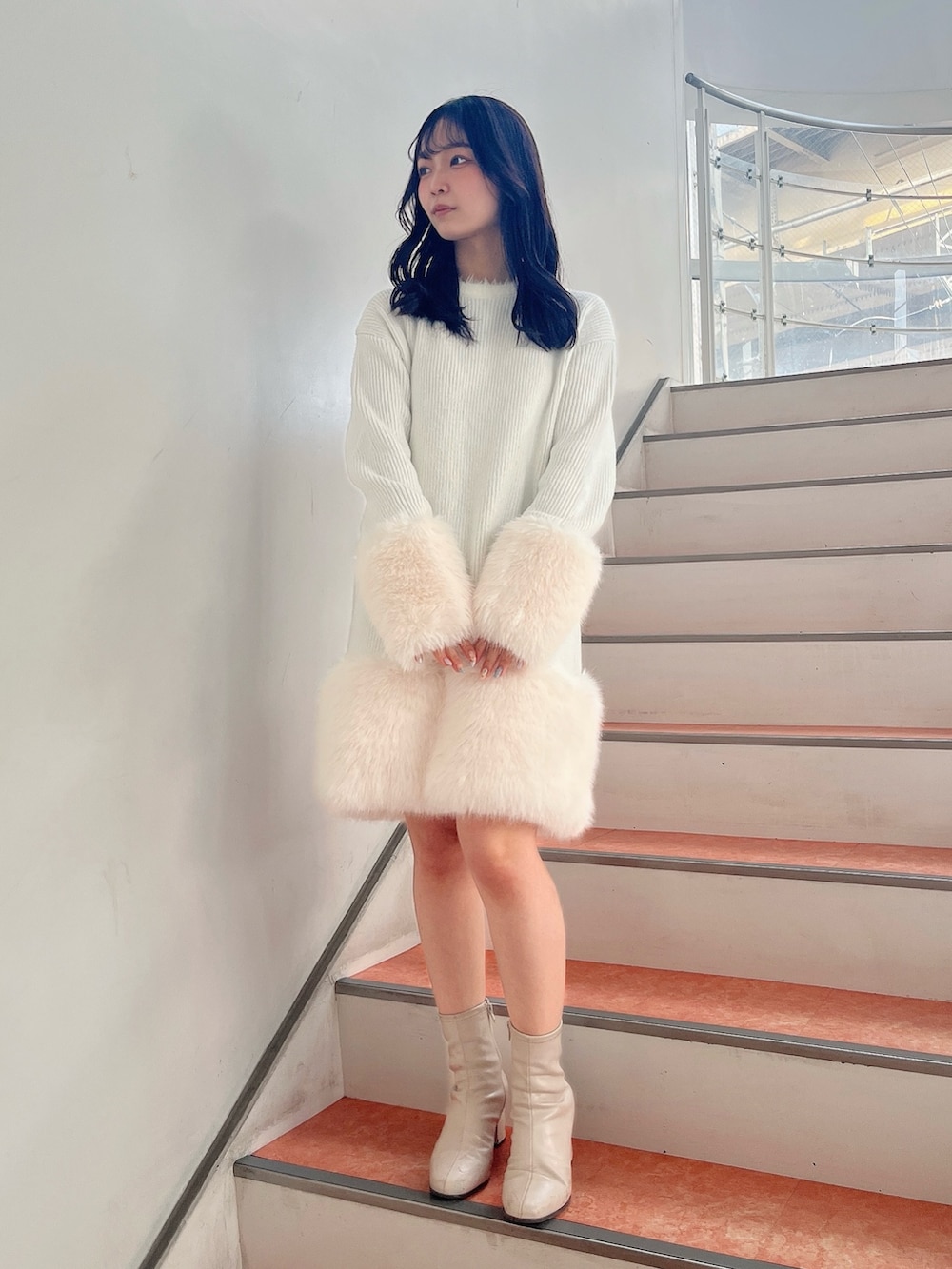 ベージュ系のブーツ、ホワイト系のワンピースを着用したレディースの冬コーディネートの2枚目の写真