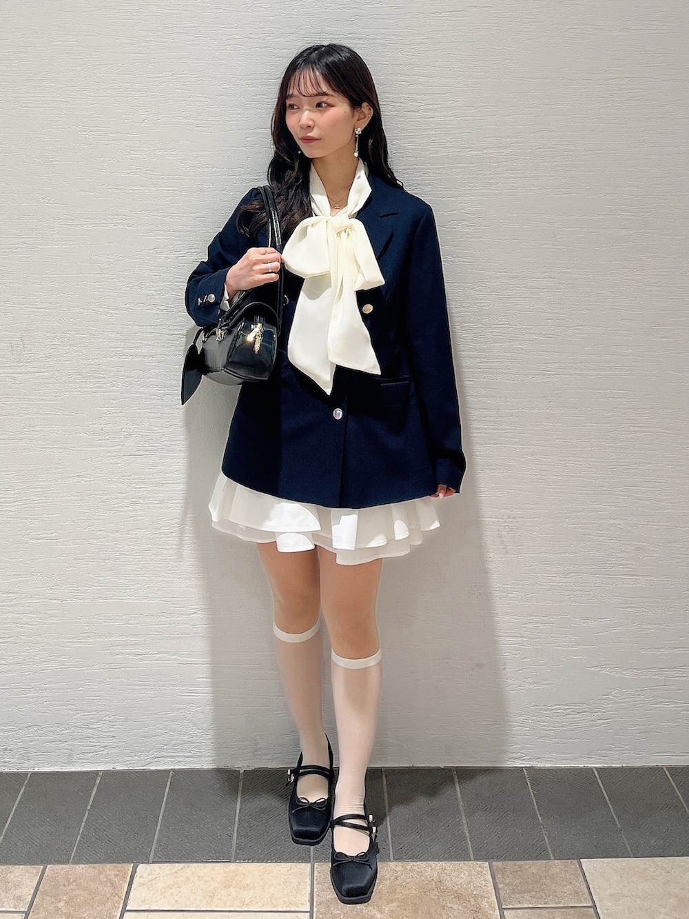 ホワイト系のシャツ/ブラウス、ホワイト系のスカート、ブラック系のバレエシューズを着用したレディースの春コーディネートの3枚目の写真