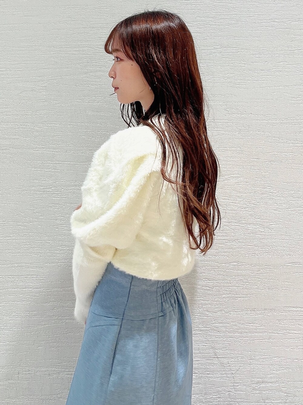 ホワイト系のニット/セーター、ブルー系のスカート、ベージュ系のブーツを着用したレディースの冬コーディネートの5枚目の写真