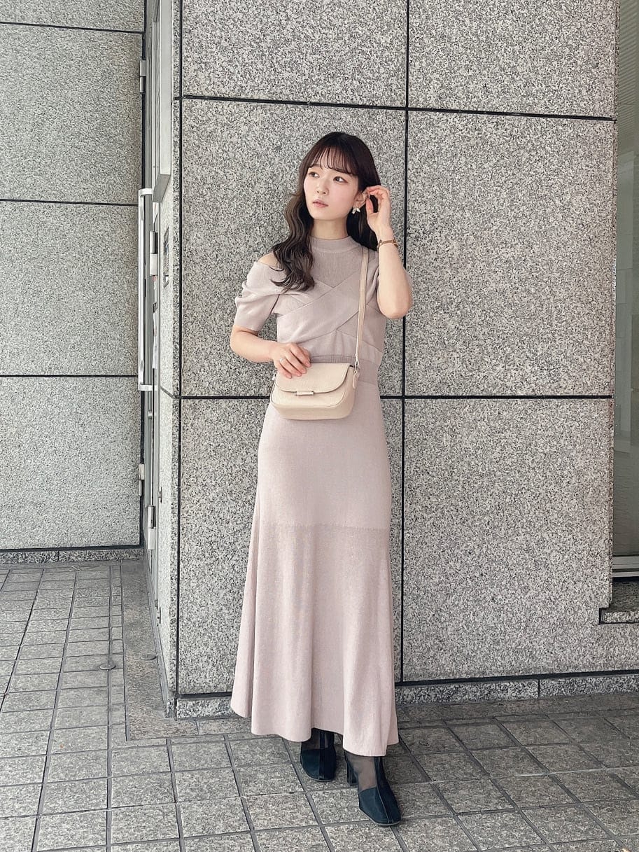 ピンク系のワンピース、ブラック系のブーツ、ホワイト系のショルダーバッグを着用したレディースの冬コーディネートの2枚目の写真