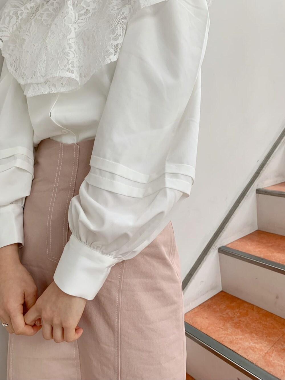 ホワイト系のパンプス、ホワイト系のシャツ/ブラウス、ピンク系のスカートを着用したレディースの冬コーディネートの7枚目の写真