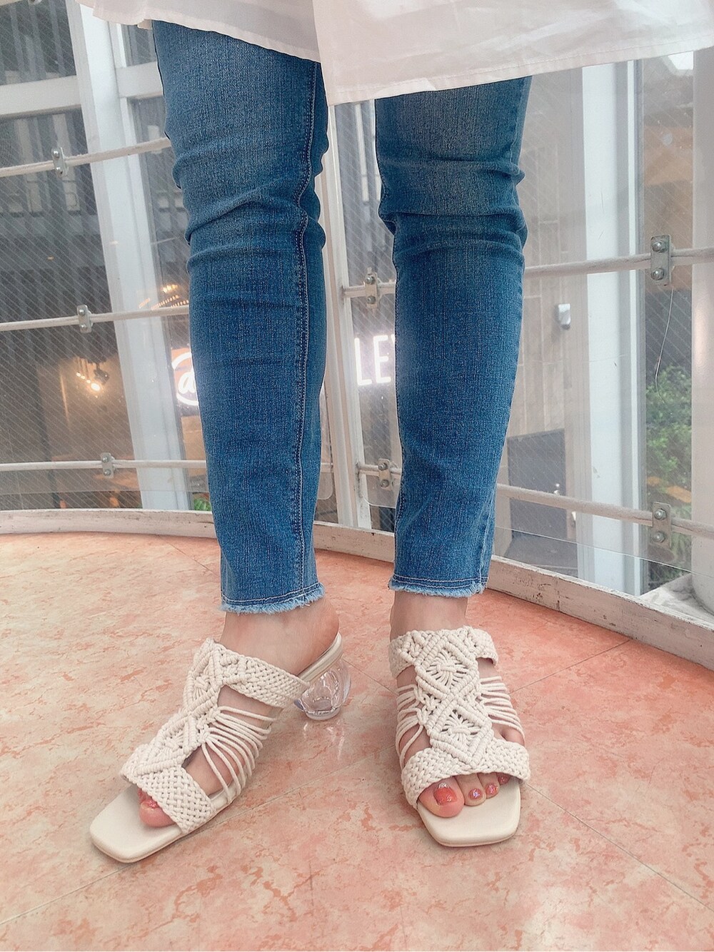 ブルー系のデニムパンツ、ホワイト系のシャツ/ブラウス、ホワイト系のサンダルを着用したレディースの春コーディネートの5枚目の写真