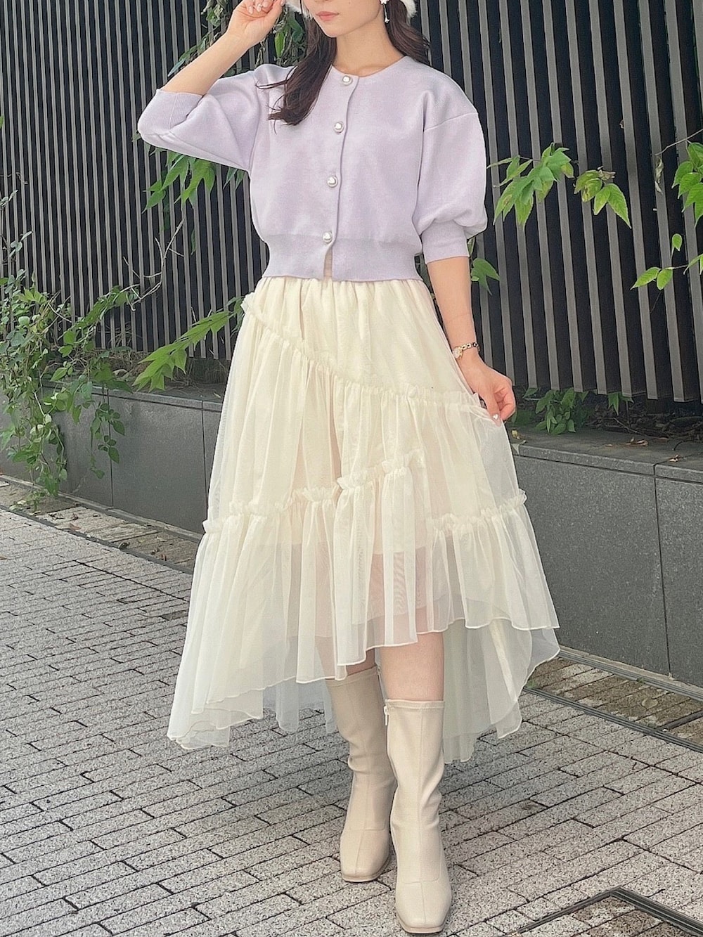 パープル系のカーディガン/ボレロ、ホワイト系のスカート、ホワイト系のブーツを着用したレディースの夏コーディネートの4枚目の写真