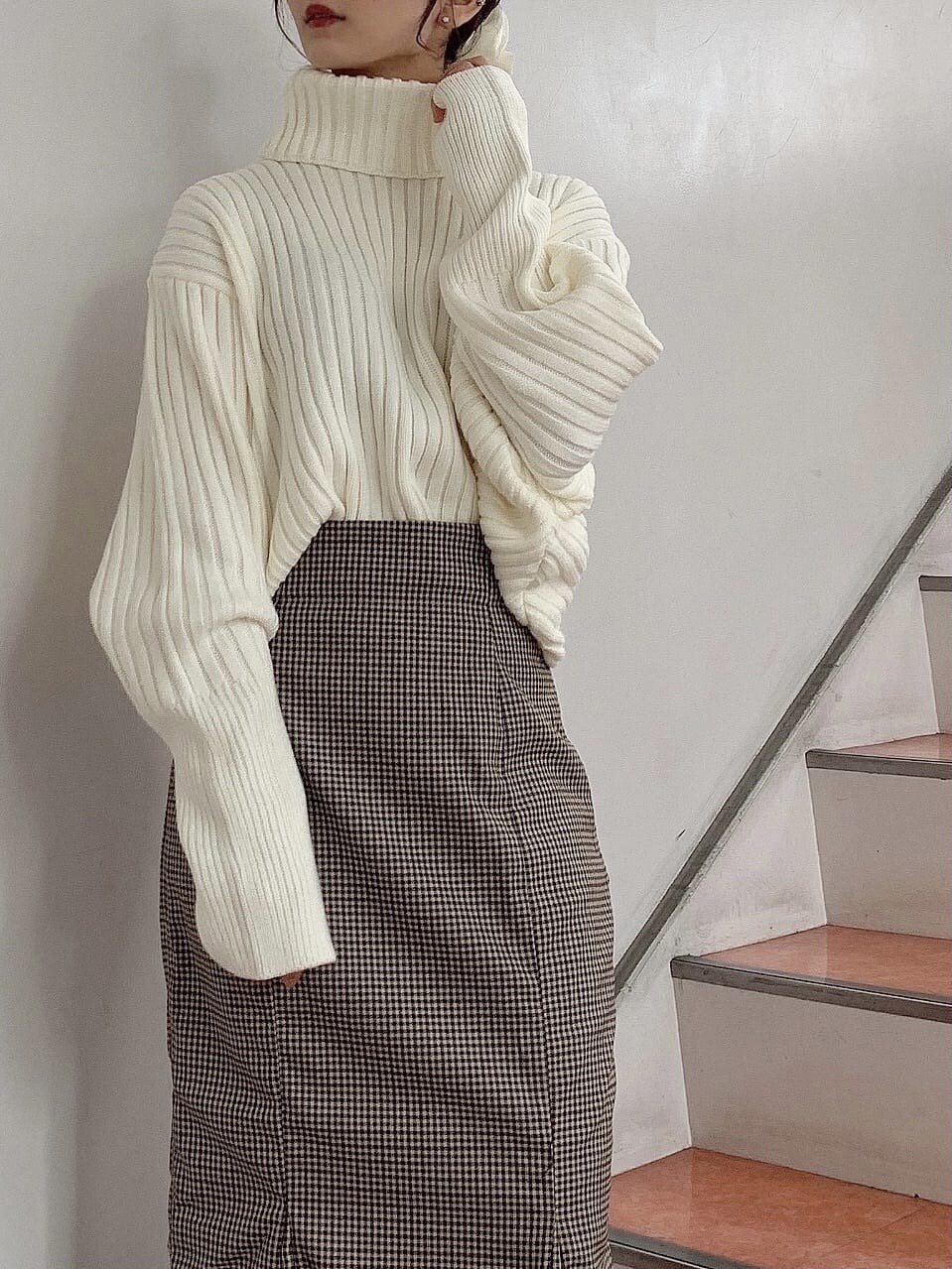 ブラウン系のブーツ、ブラウン系のスカート、ホワイト系のニット/セーターを着用したレディースの秋コーディネートの5枚目の写真