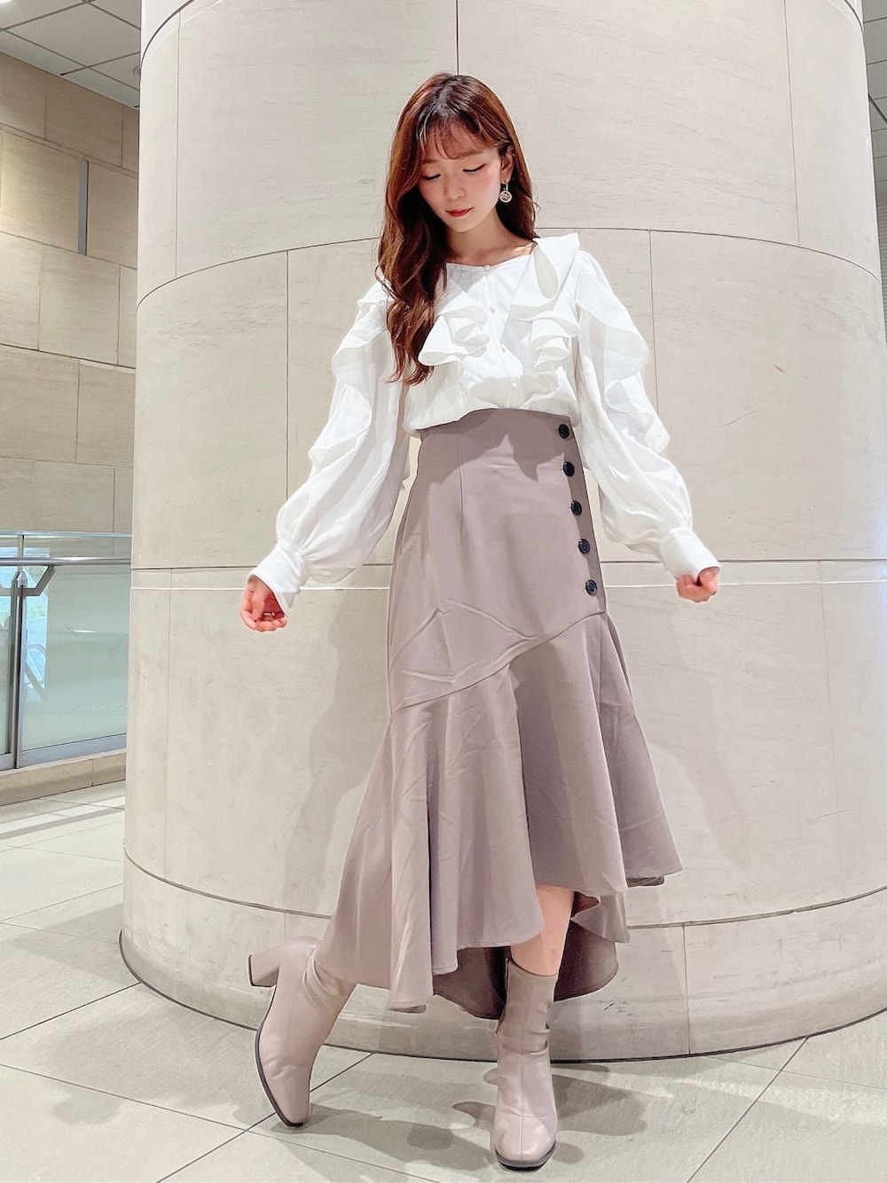 ベージュ系のブーツ、ベージュ系のスカート、ホワイト系のシャツ/ブラウスを着用したレディースの秋コーディネートの3枚目の写真