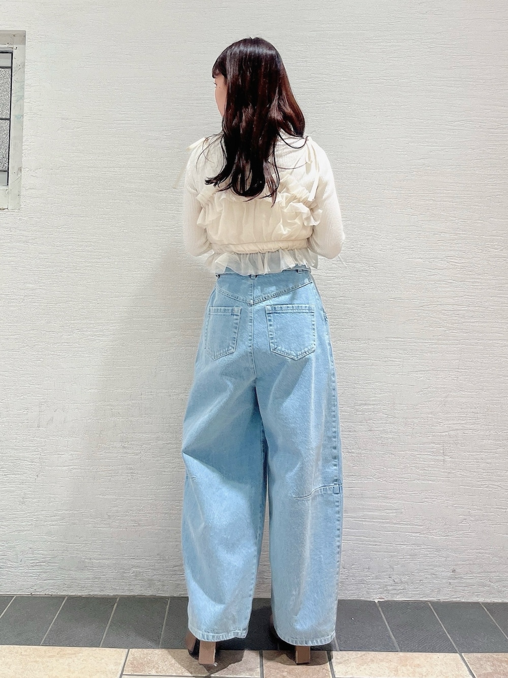 ベージュ系のブーツ、ブルー系のデニムパンツ、ベージュ系のキャミソールを着用したレディースの冬コーディネートの5枚目の写真