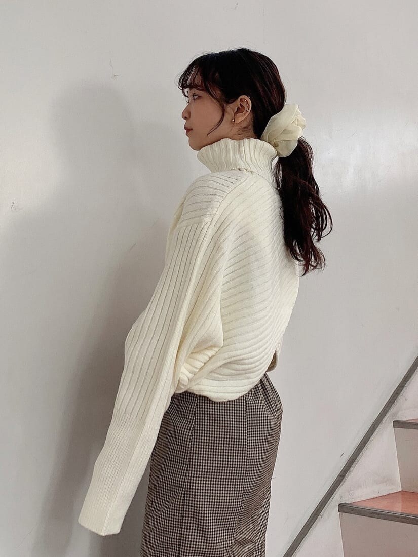 ブラウン系のブーツ、ブラウン系のスカート、ホワイト系のニット/セーターを着用したレディースの秋コーディネートの7枚目の写真