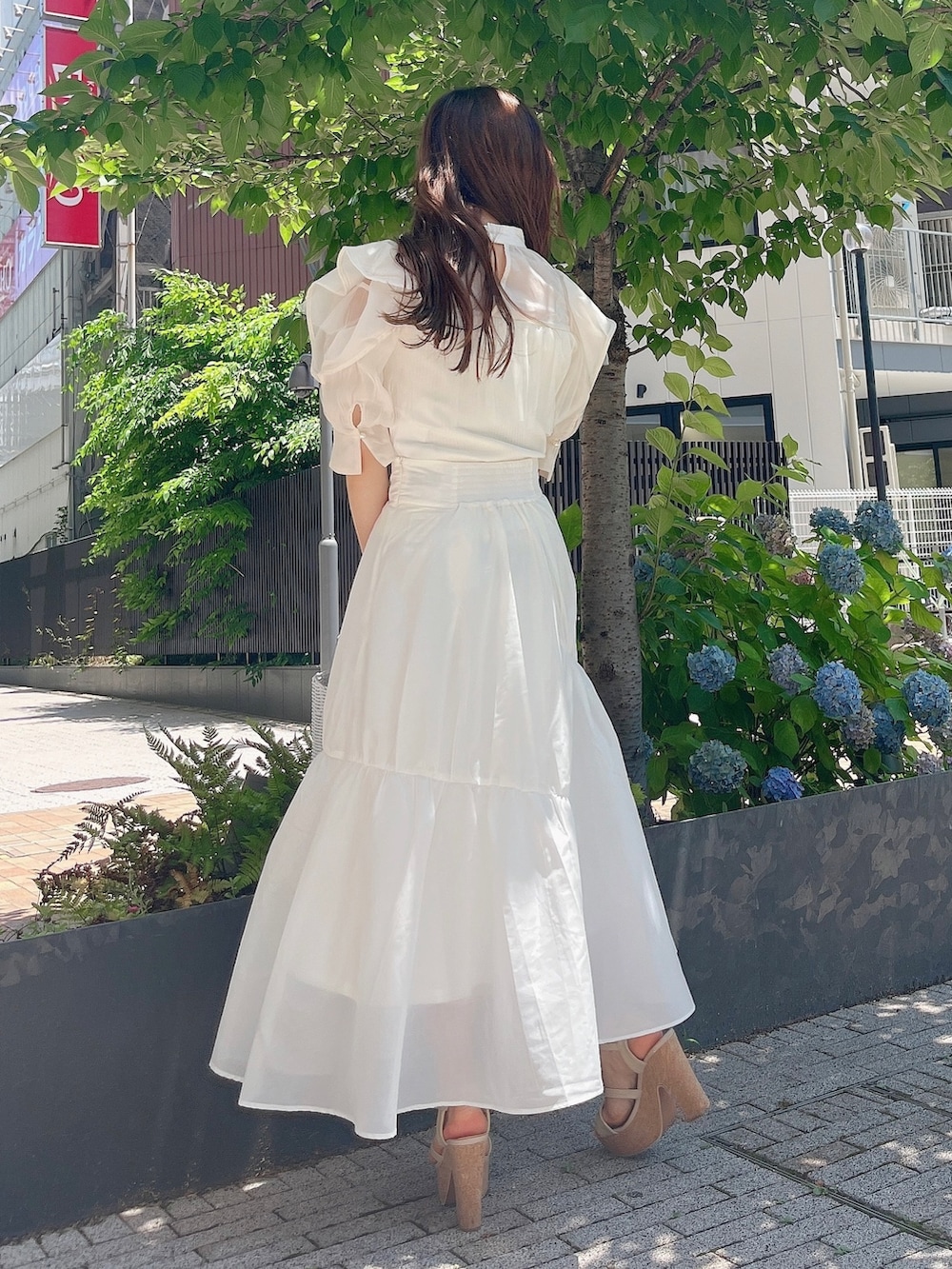 ホワイト系のシャツ/ブラウス、ホワイト系のスカート、ホワイト系のサンダルを着用したレディースの夏コーディネートの5枚目の写真