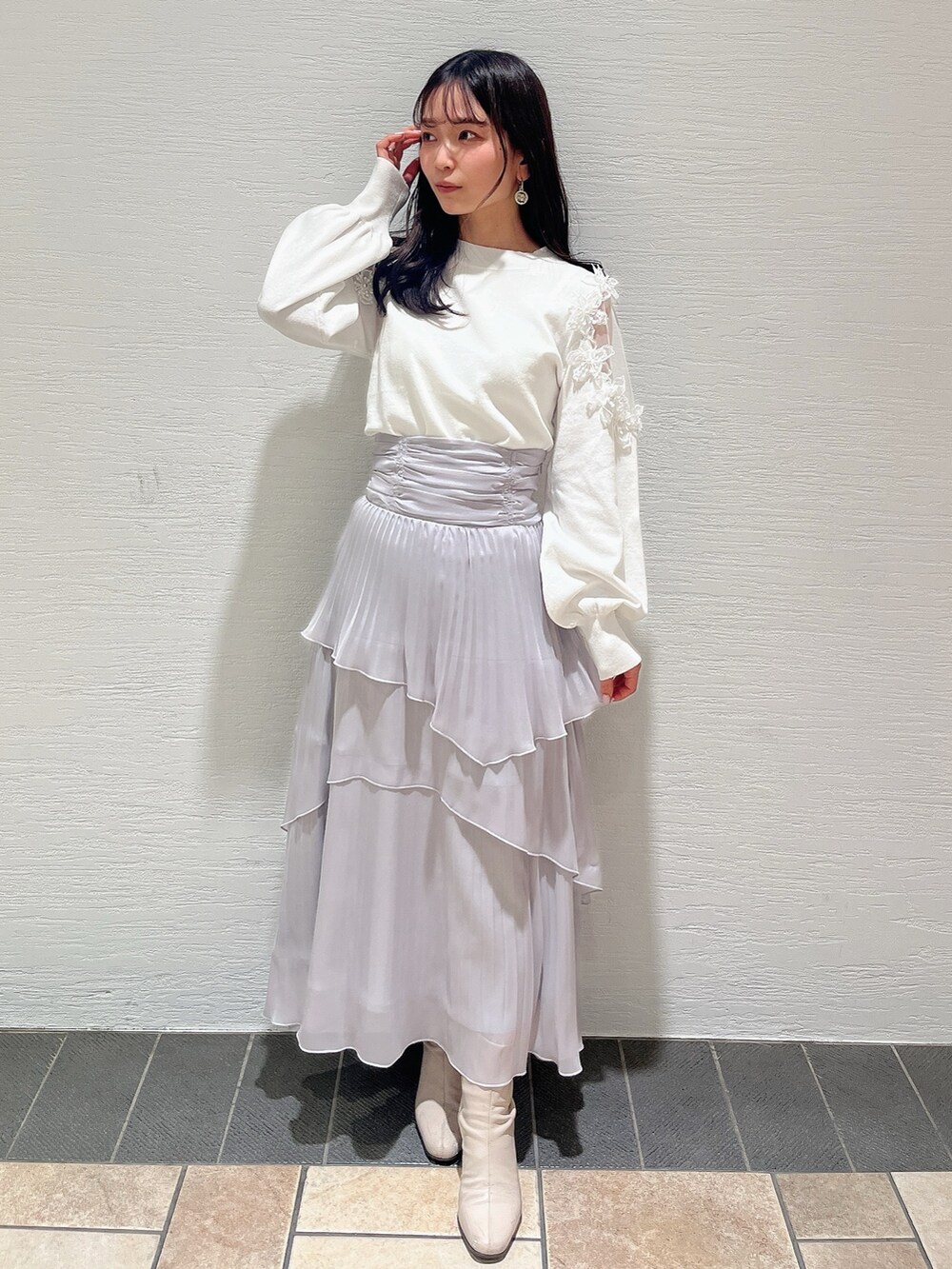 ベージュ系のブーツ、グレー系のスカート、ホワイト系のニット/セーターを着用したレディースの冬コーディネートの2枚目の写真