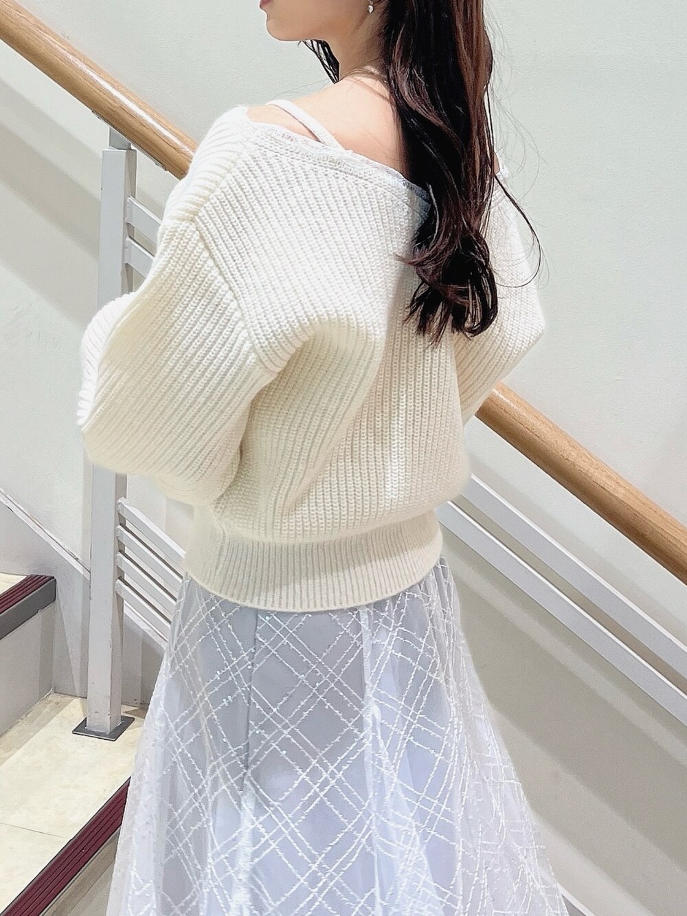 ホワイト系のニット/セーター、グレー系のスカート、ベージュ系のブーツを着用したレディースの冬コーディネートの7枚目の写真