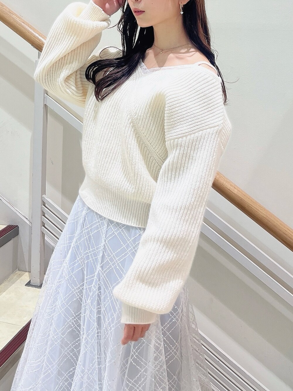 ホワイト系のニット/セーター、グレー系のスカート、ベージュ系のブーツを着用したレディースの冬コーディネートの9枚目の写真