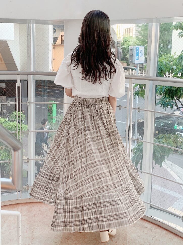 ホワイト系のシャツ/ブラウス、ベージュ系のスカート、ホワイト系のパンプスを着用したレディースの夏コーディネートの3枚目の写真