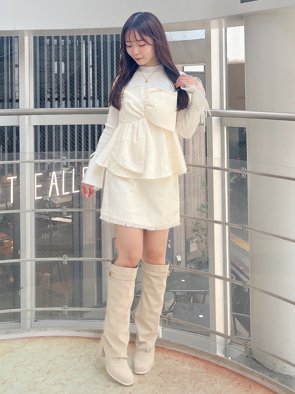 ホワイト系のニット/セーター、ホワイト系のタンクトップ、ホワイト系のスカートを着用したレディースの秋コーディネートの2枚目の写真