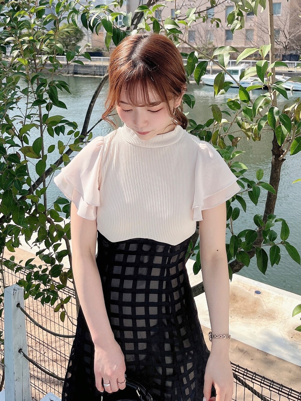 ホワイト系のワンピース、ブラック系のパンプスを着用したレディースの春コーディネートの6枚目の写真