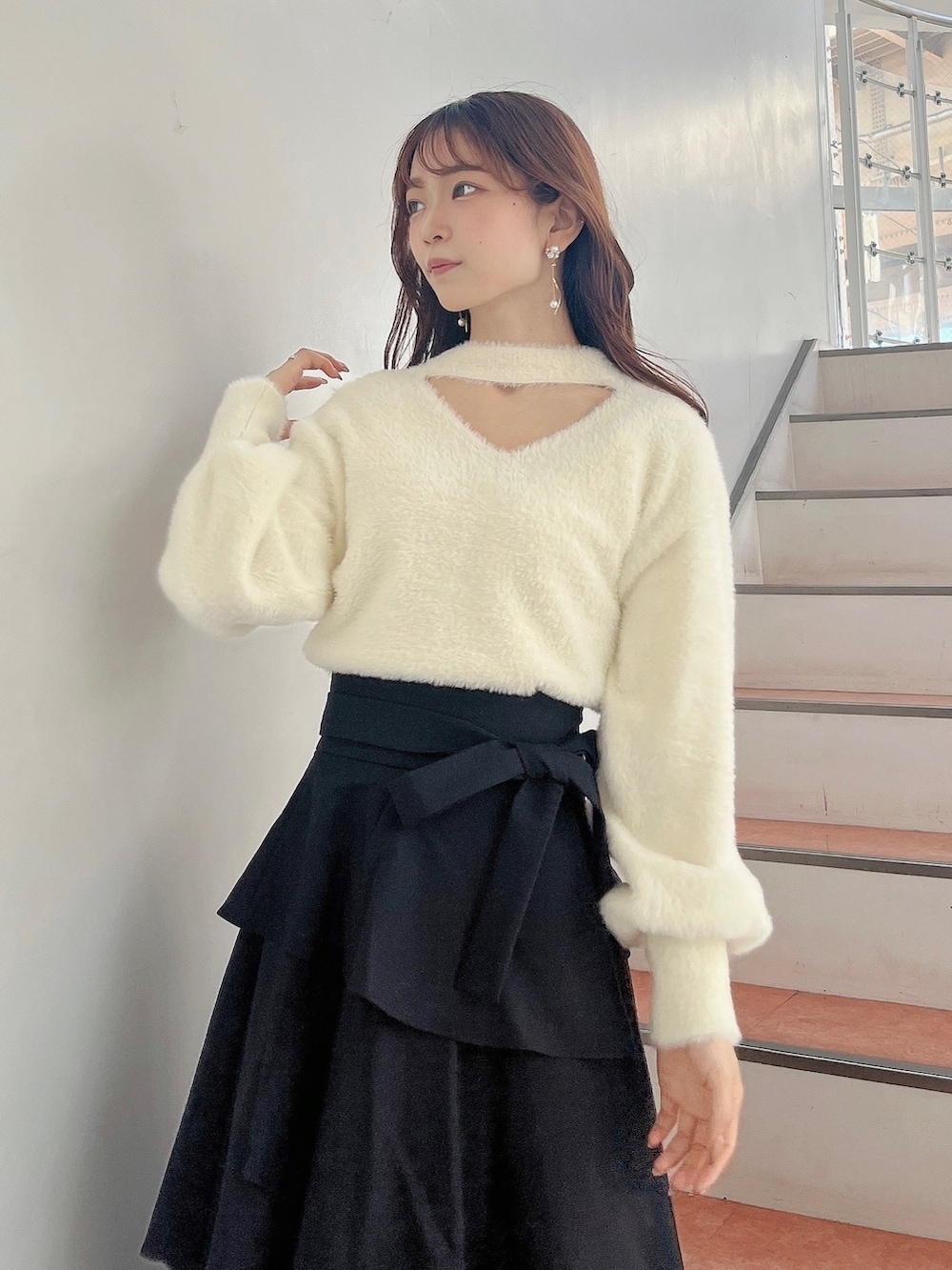 ホワイト系のブーツ、ブラック系のスカート、ホワイト系のニット/セーターを着用したレディースの秋コーディネートの6枚目の写真