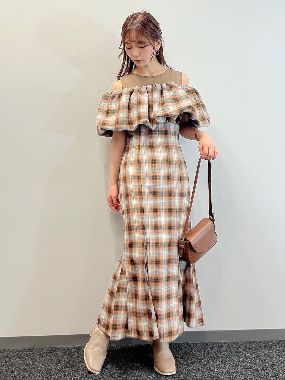 オレンジ系のワンピース、ベージュ系のブーツを着用したレディースの夏コーディネートの2枚目の写真