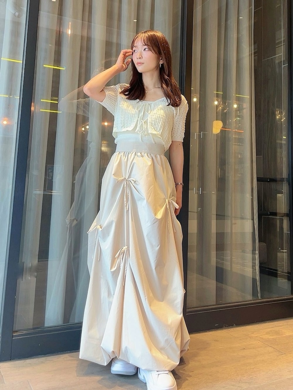 ホワイト系のニット/セーター、ホワイト系のスカートを着用したレディースの夏コーディネートの3枚目の写真