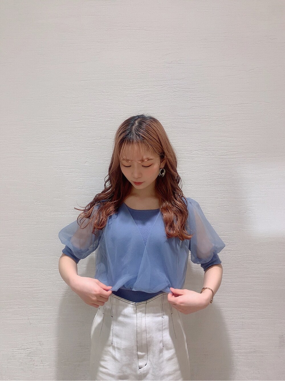 ホワイト系のスカート、ホワイト系のサンダル、ブルー系のニット/セーターを着用したレディースの春コーディネートの3枚目の写真