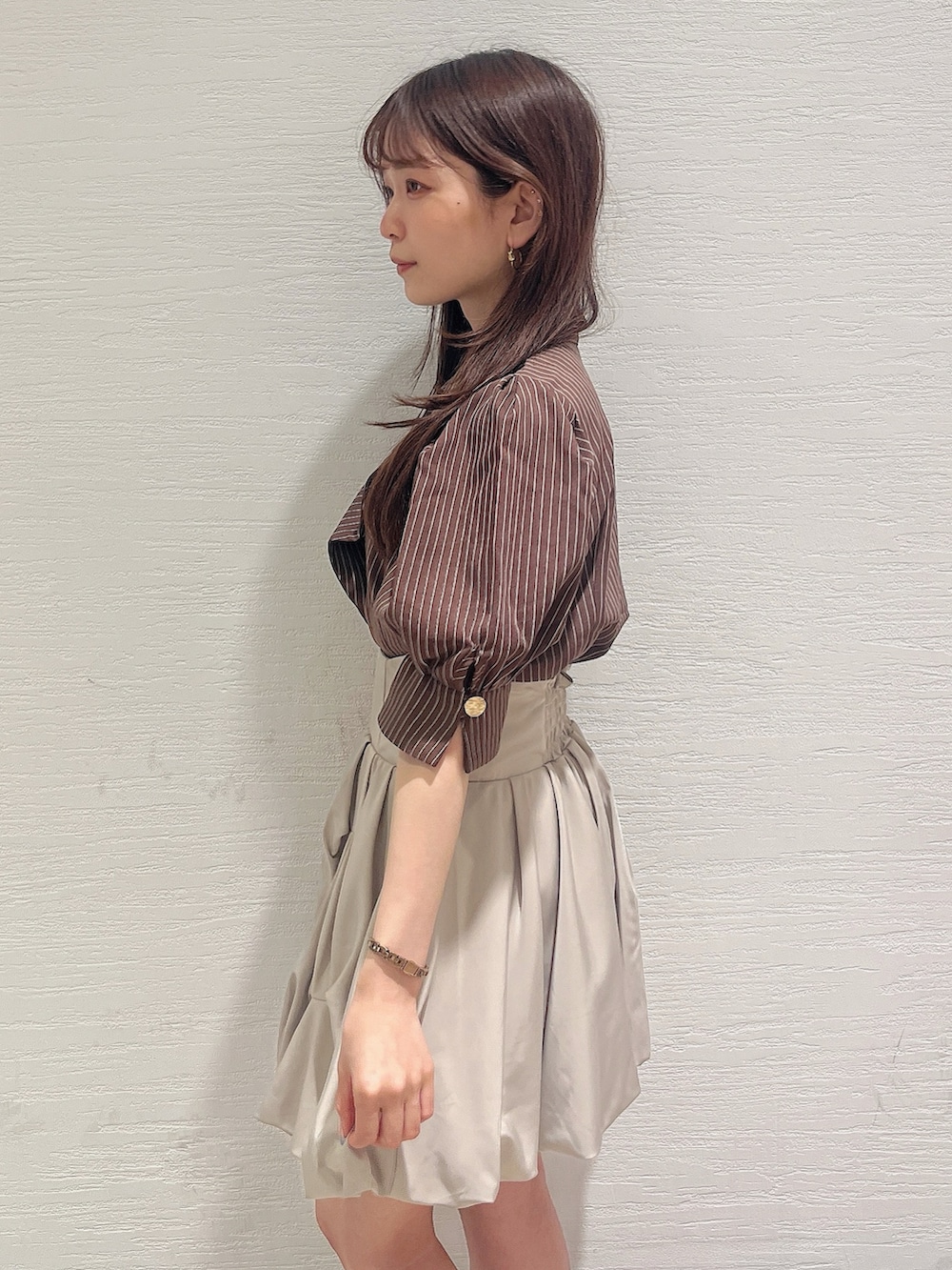 ブラウン系のシャツ/ブラウス、ベージュ系のスカート、ホワイト系のサンダルを着用したレディースの夏コーディネートの6枚目の写真