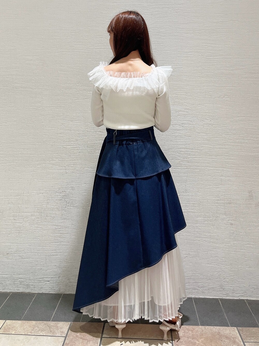 ベージュ系のパンプス、ブルー系のスカート、ホワイト系のニット/セーターを着用したレディースの秋コーディネートの2枚目の写真