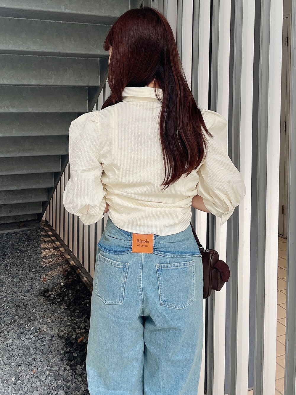 イエロー系のシャツ/ブラウス、ブルー系のデニムパンツ、ブラウン系のボストンバッグを着用したレディースの夏コーディネートの7枚目の写真