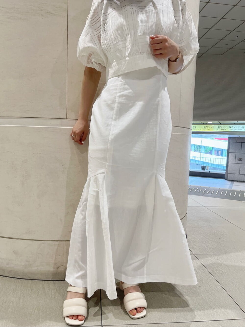 ホワイト系のワンピース、ホワイト系のサンダル、ベージュ系のハットを着用したレディースの夏コーディネートの9枚目の写真