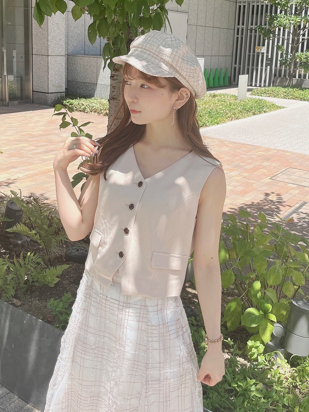 ベージュ系のベスト、ベージュ系のスカート、ホワイト系のローファーを着用したレディースの夏コーディネートの6枚目の写真