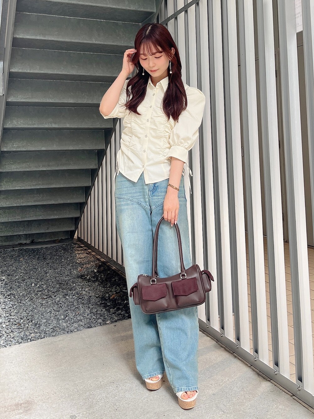 イエロー系のシャツ/ブラウス、ブルー系のデニムパンツ、ブラウン系のボストンバッグを着用したレディースの夏コーディネートの2枚目の写真