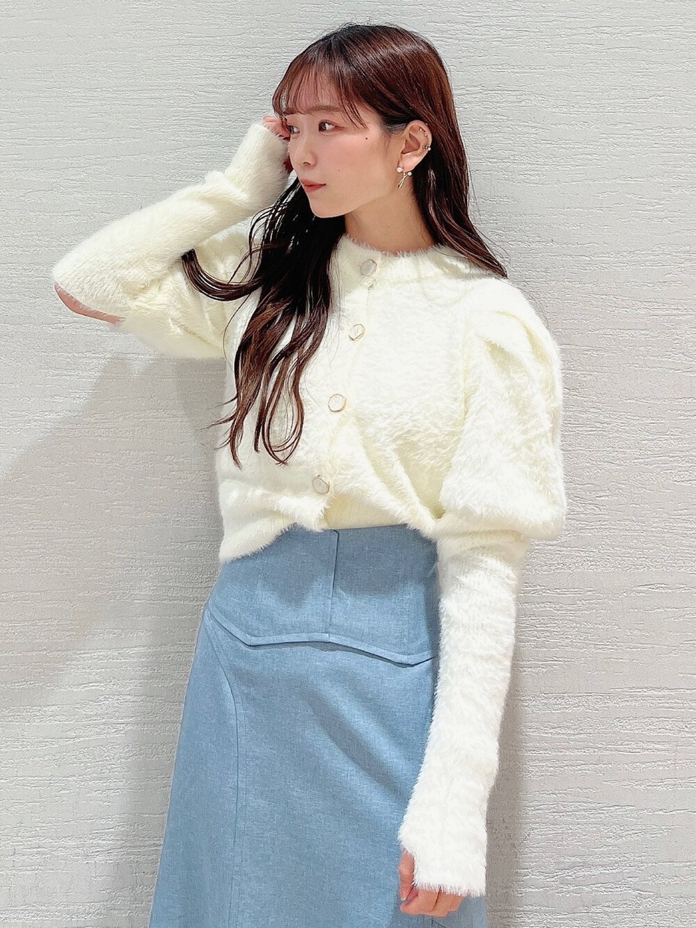 ホワイト系のニット/セーター、ブルー系のスカート、ベージュ系のブーツを着用したレディースの冬コーディネートの6枚目の写真