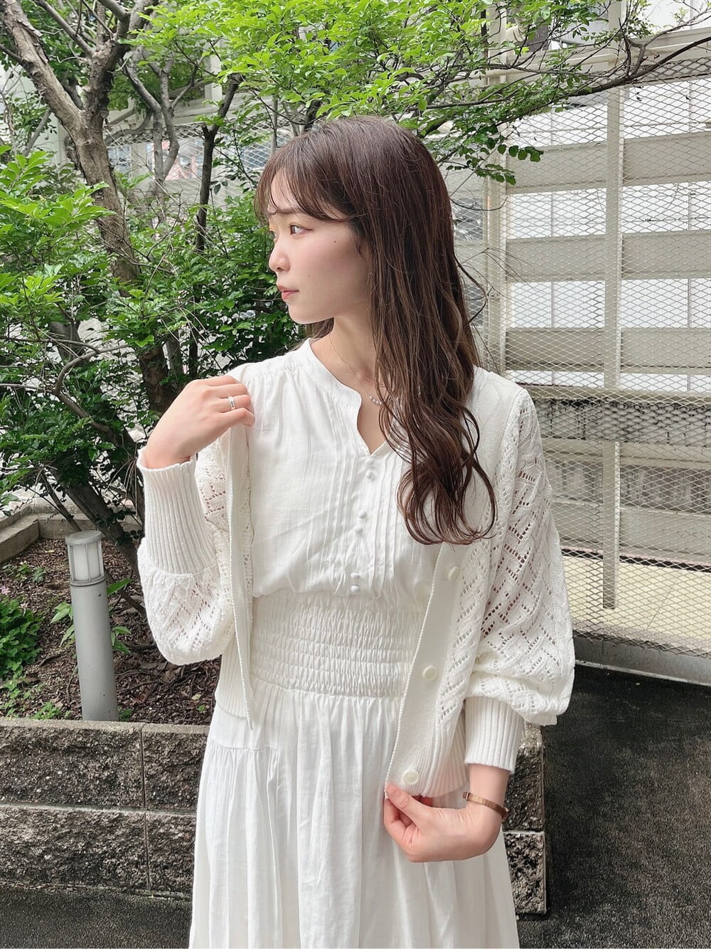 ホワイト系のワンピース、ベージュ系のサンダル、ホワイト系のカーディガン/ボレロを着用したレディースの春コーディネートの2枚目の写真