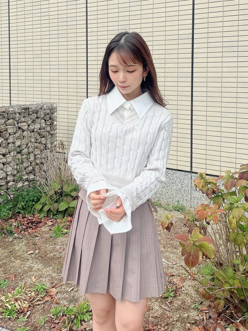 ベージュ系のブーツ、ベージュ系のスカート、グレー系のニット/セーターを着用したレディースの冬コーディネートの6枚目の写真