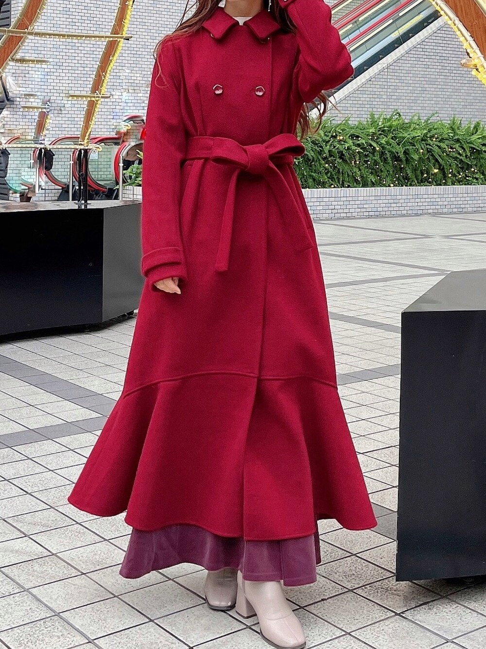 レッド系のその他アウター、パープル系のワンピース、ベージュ系のブーツを着用したレディースの冬コーディネートの2枚目の写真