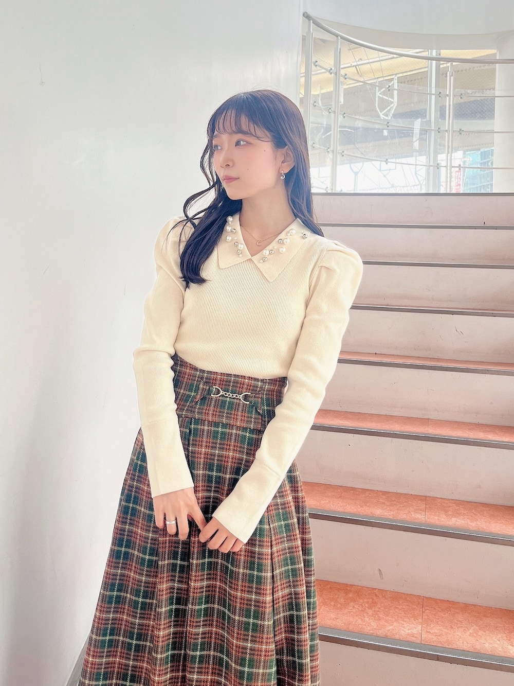 ホワイト系のニット/セーター、グリーン系のスカート、ベージュ系のブーツを着用したレディースの秋コーディネートの9枚目の写真