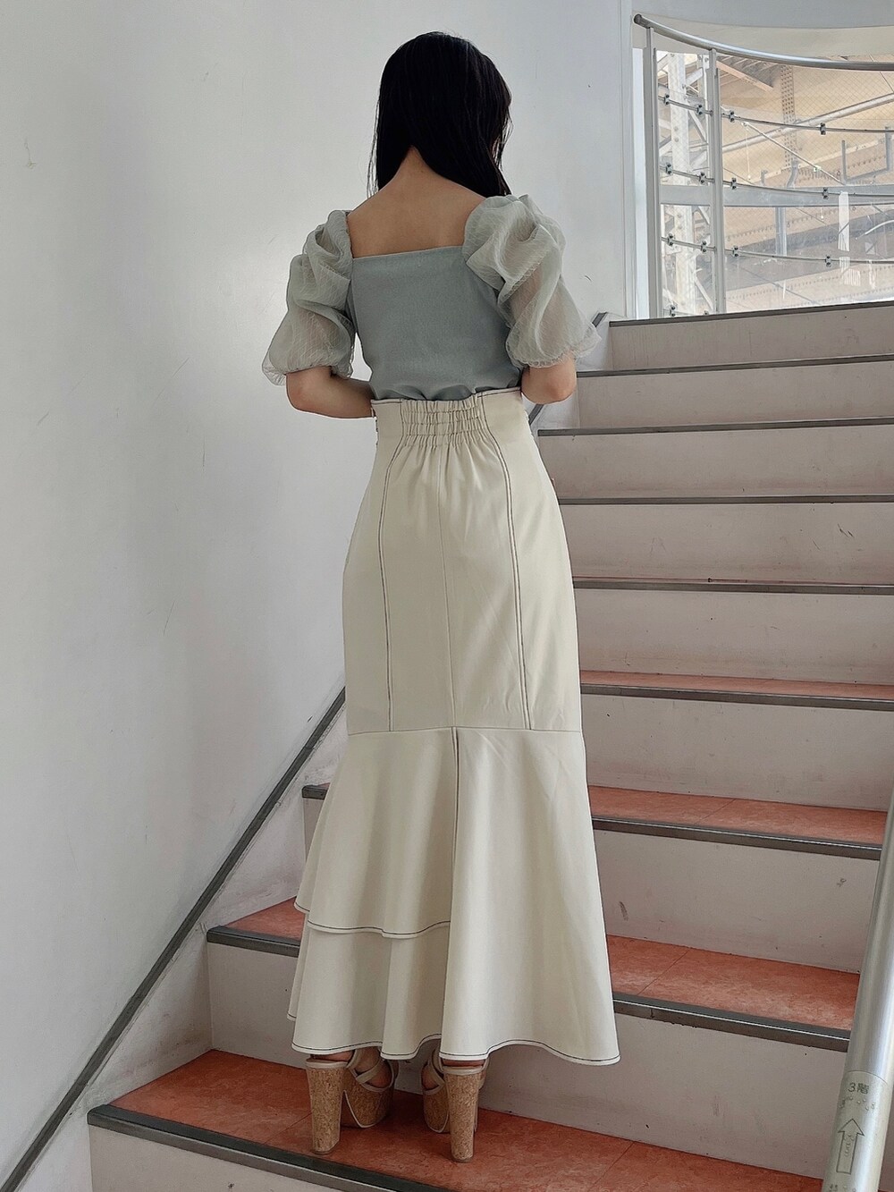 グリーン系のTシャツ/カットソー、ホワイト系のスカート、ホワイト系のサンダルを着用したレディースの春コーディネートの3枚目の写真