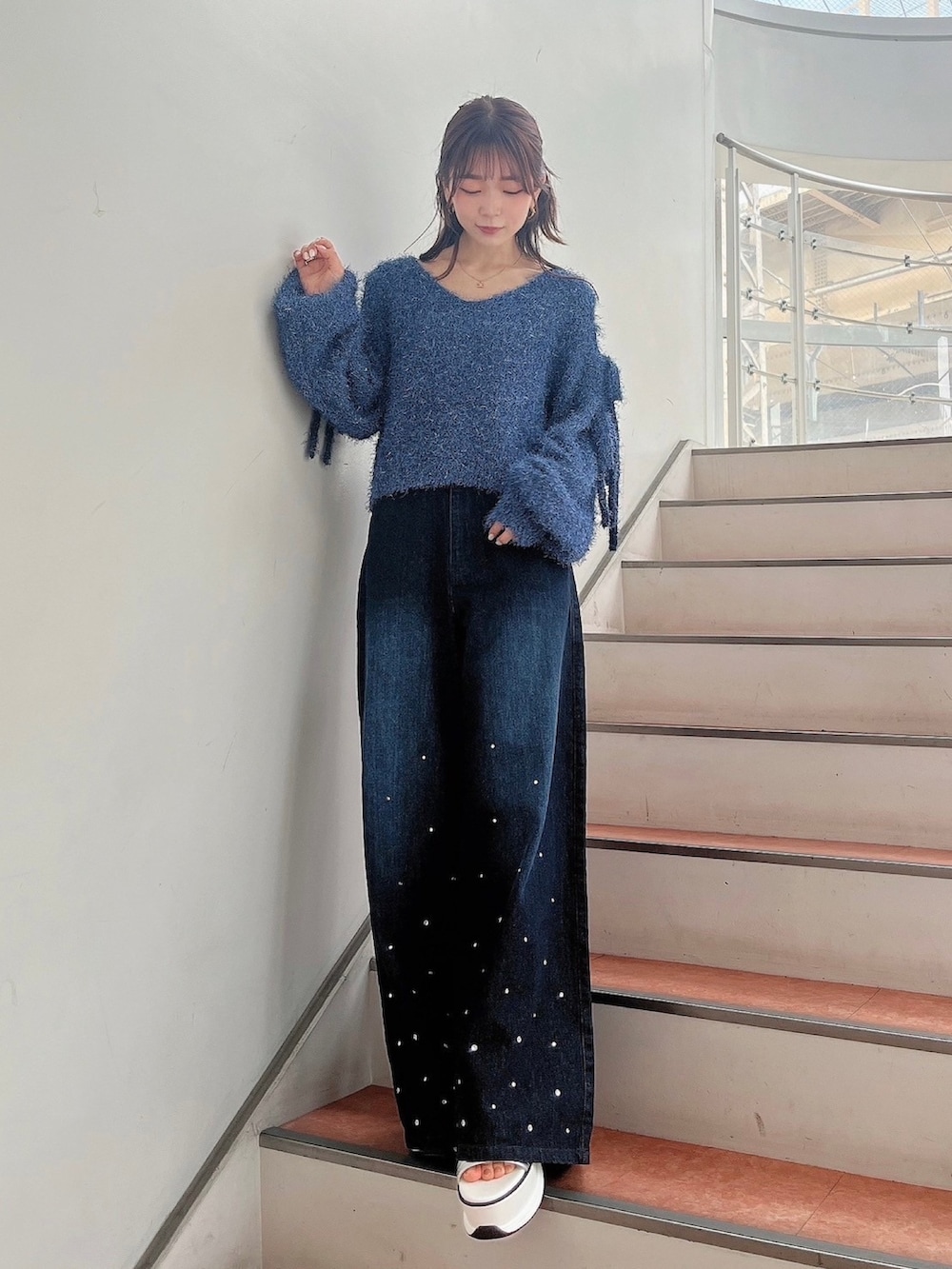 ブルー系のニット/セーター、ブルー系のデニムパンツ、ホワイト系のサンダルを着用したレディースの夏コーディネートの5枚目の写真