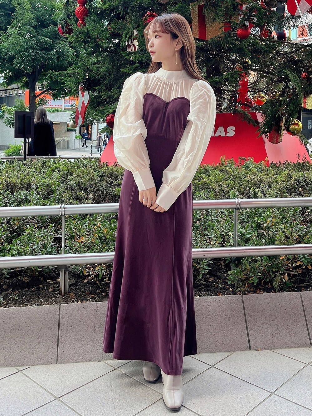 ベージュ系のブーツ、パープル系のワンピースを着用したレディースの冬コーディネートの3枚目の写真