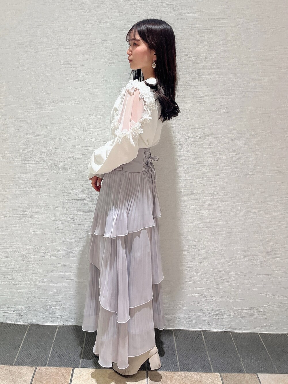 ベージュ系のブーツ、グレー系のスカート、ホワイト系のニット/セーターを着用したレディースの冬コーディネートの4枚目の写真