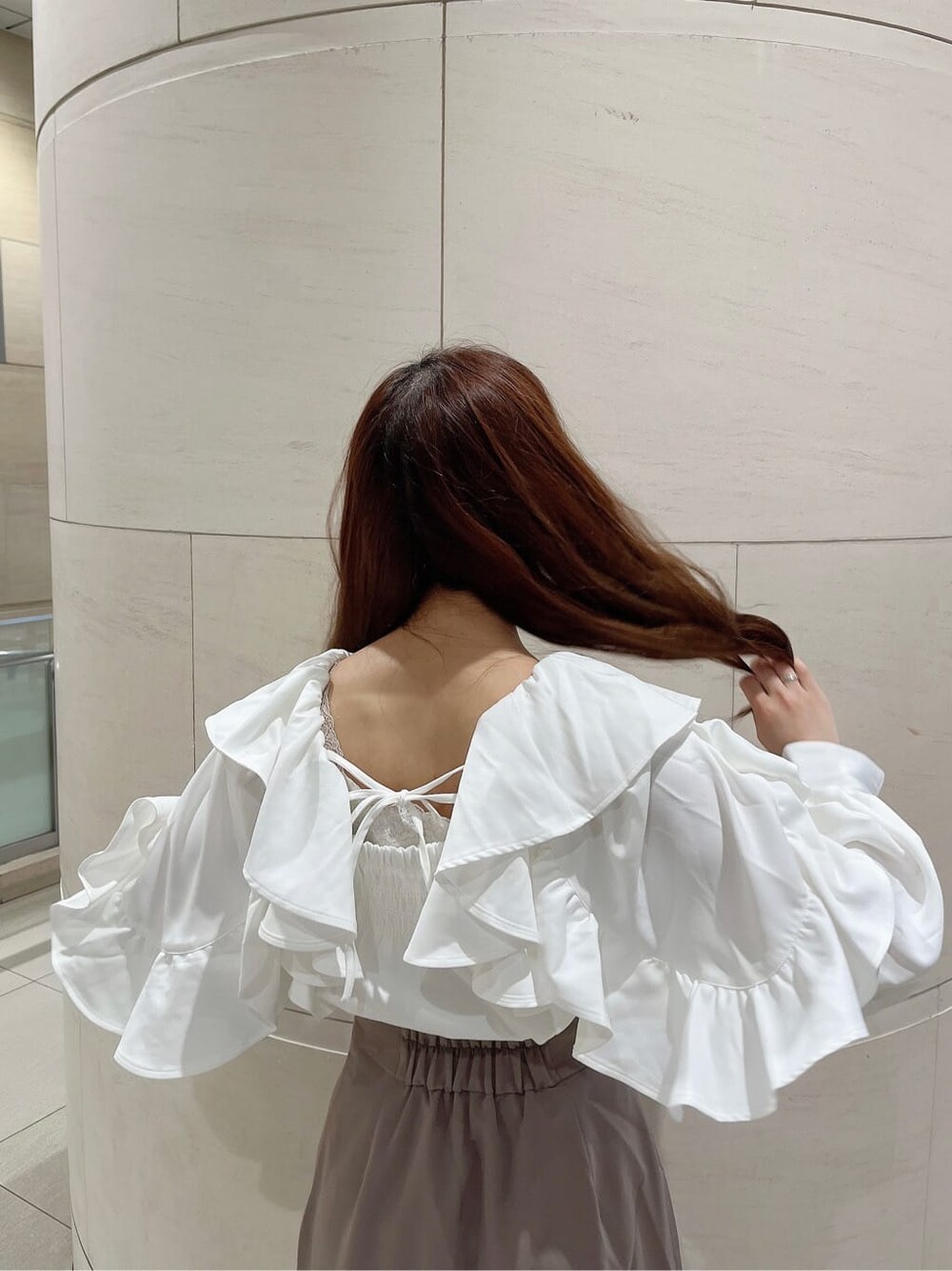 ベージュ系のブーツ、ベージュ系のスカート、ホワイト系のシャツ/ブラウスを着用したレディースの秋コーディネートの7枚目の写真