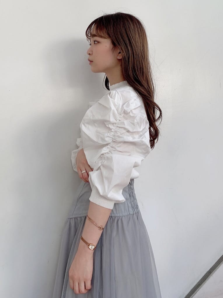 グレー系のスカート、ホワイト系のパンプス、ホワイト系のニット/セーターを着用したレディースの秋コーディネートの5枚目の写真