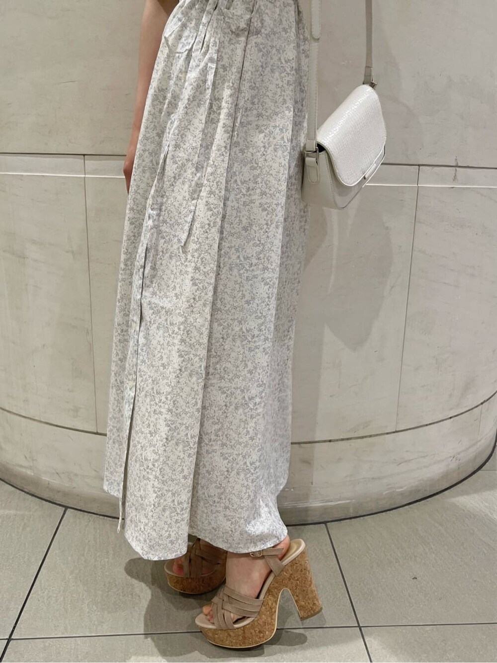 ベージュ系のサンダル、ホワイト系のワンピース、ホワイト系のハットを着用したレディースの春コーディネートの9枚目の写真