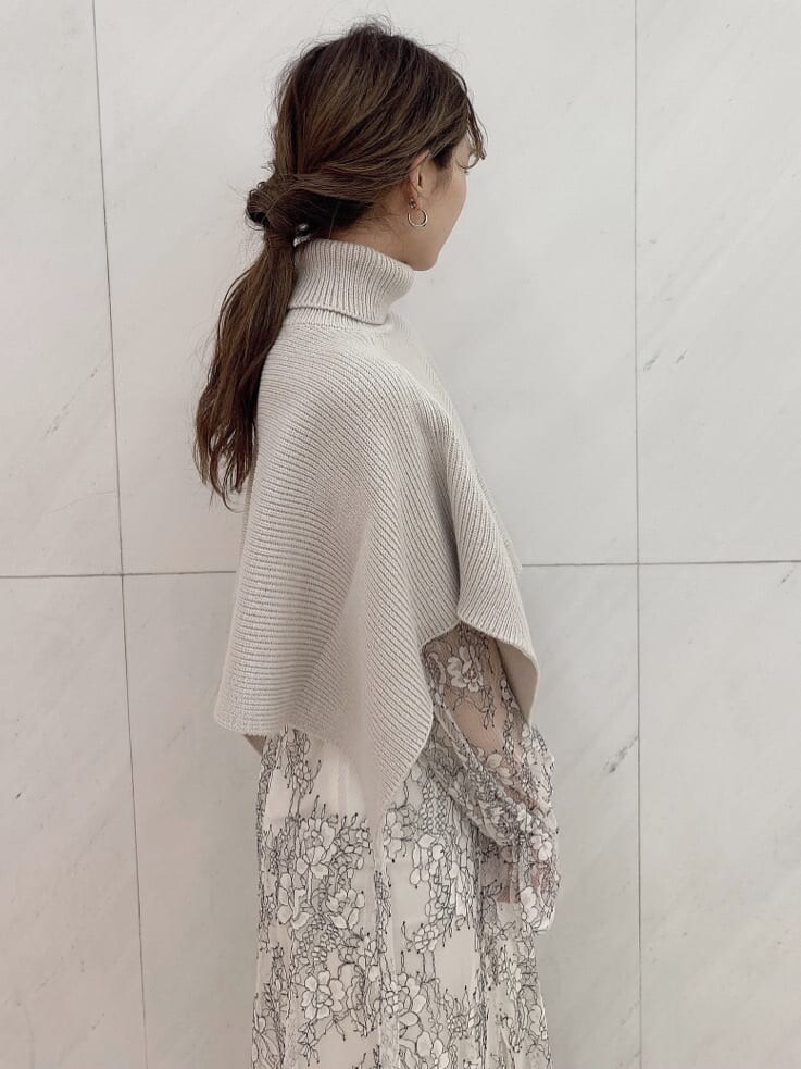 ホワイト系のワンピース、ベージュ系のニット/セーター、ホワイト系のパンプスを着用したレディースの秋コーディネートの4枚目の写真