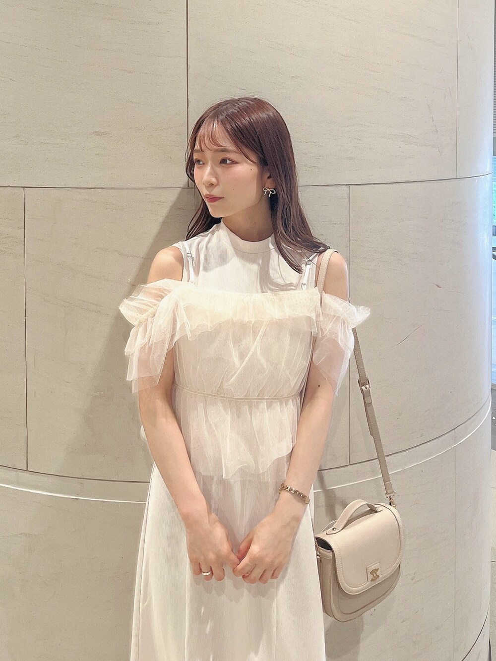 ホワイト系のワンピース、ホワイト系のパンプス、ホワイト系のハンドバッグを着用したレディースの夏コーディネートの6枚目の写真