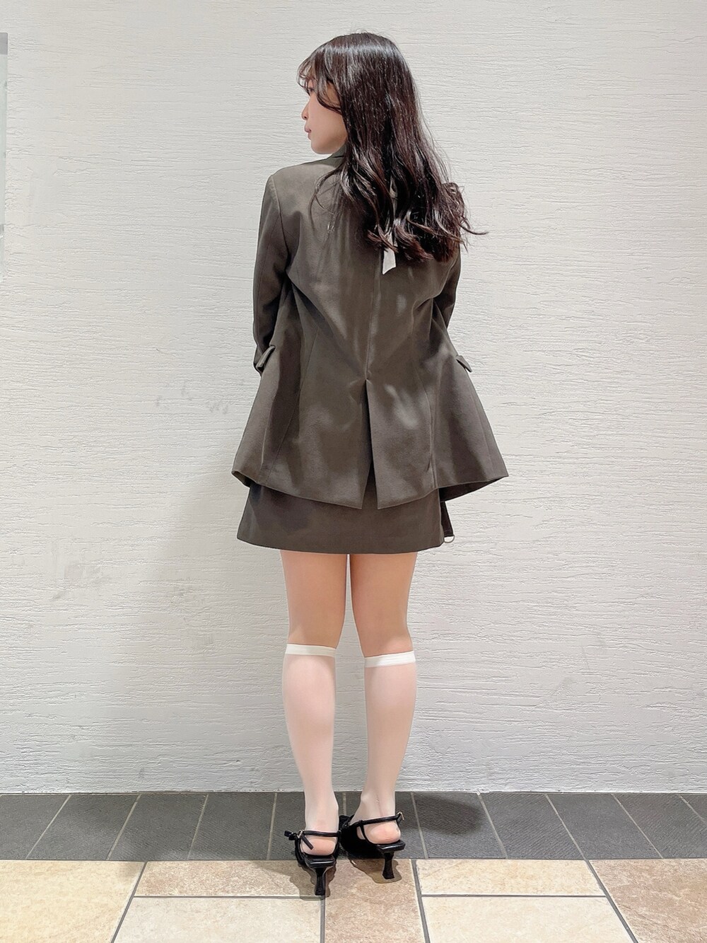 ホワイト系のTシャツ/カットソー、ブラウン系のテーラードジャケット、ブラウン系のスカートを着用したレディースの春コーディネートの6枚目の写真