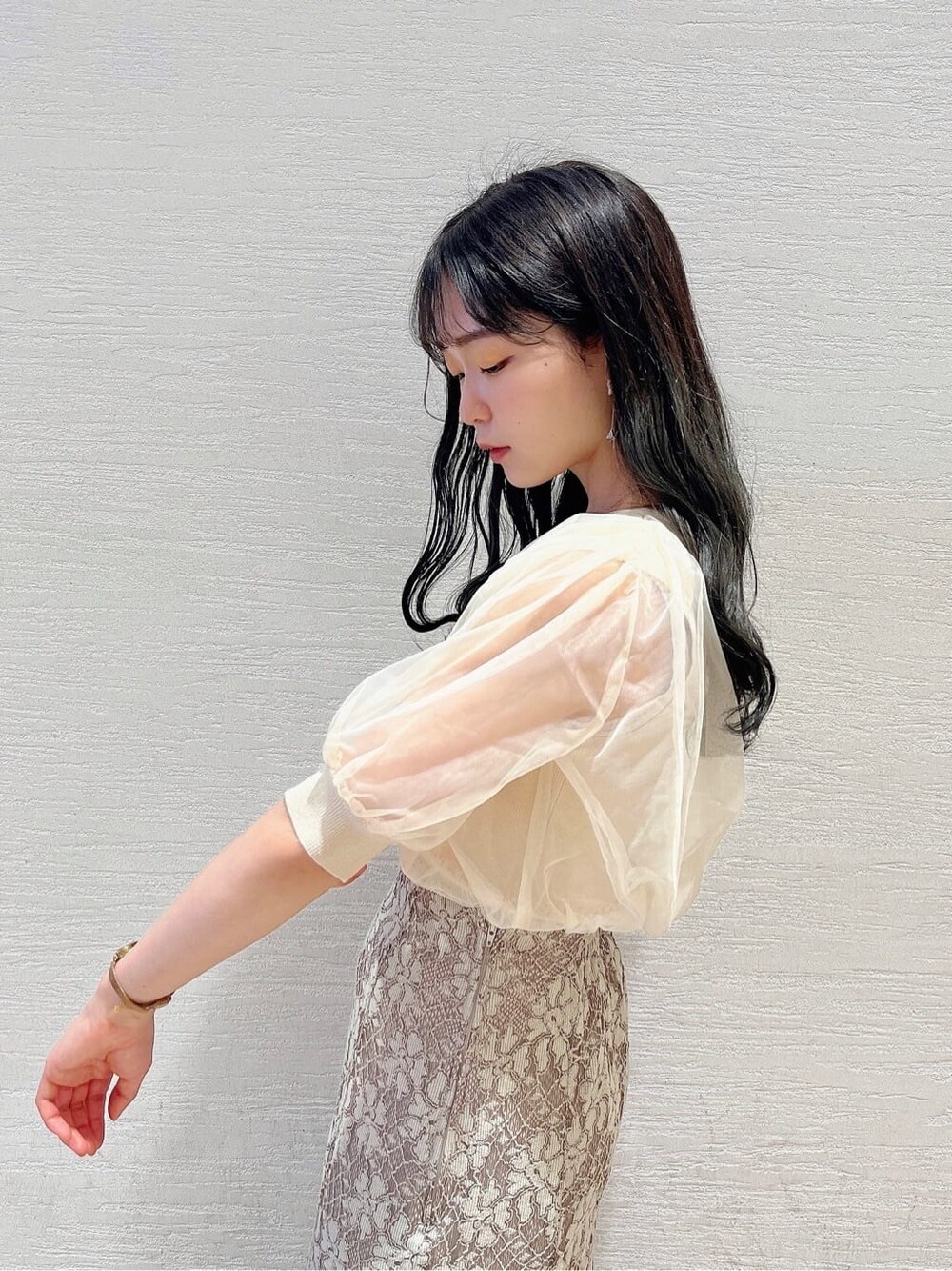 ベージュ系のスカート、ホワイト系のパンプス、ホワイト系のニット/セーターを着用したレディースの春コーディネートの5枚目の写真